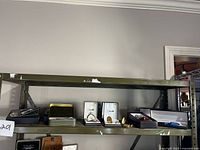 Shelving unit with assorted pocket watches and pen boxes, showing a variety of boxes, some open with visible dials.