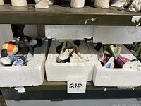 Four porcelain clown collectibles, three in original white styrofoam boxes on a shelf