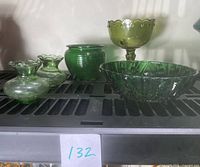 Five green glass items: two small bud vases, one ribbed planter, one pedestal bowl with scalloped edge, one footed bubble glass serving dish.