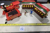 Overview of the train engine, coal tender, two passenger cars with striped awnings, and two figurines (Donald Duck and Goofy) displayed with measuring tape for scale.