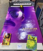 Yamaha PSS-170 Keyboard, Queen Bohemian Rhapsody poster and two books arranged on a table.