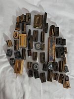 Top view of assorted vintage printing blocks with letters arranged randomly including large and small blocks.