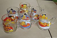 Lot of 7 vintage Garfield glass mugs with comic strip designs shown together