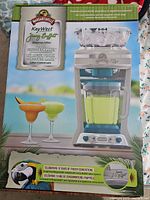 Box packaging with product image, branding, and information highlighting 10 years of frozen concoctions and Jimmy Buffett collaboration.