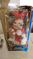 Minnie Mouse plush in original box with visible wear and tear on packaging.