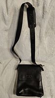 Full view of black leather messenger bag with strap extended