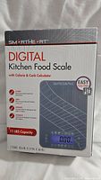 Front of the new SmartHeart Digital Kitchen Food Scale box showing features such as calorie & carb calculator, 11 lbs capacity, easy food prep.