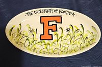 Top view of ceramic platter with University of Florida 'F' logo and hand-painted floral decoration