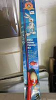 Photo of vintage Bugs Bunny fishing rod kit in original packaging showing Bugs Bunny cartoon on the blue cardboard backing and rod with reel visible.