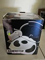 Original box for M. Kamenstein cow design tea kettle showing the kettle and cow spots graphics.