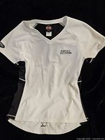 Full front view of the white and black women's Harley Davidson shirt showing logo, size XL, and color contrast.