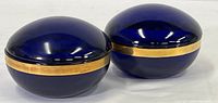 Two matching cobalt blue and gold painted covered jewelry dishes shown side by side on a white background