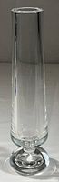 Full view of tall clear Baccarat bud vase, showing thick walls and cylindrical shape.