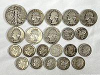 Full lot of U.S. silver coins including half dollars, quarters, and dimes arranged on white cloth.