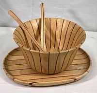 Photo showing complete salad set with bowl, platter, and two serving utensils with vertical darker wood inlay stripes