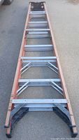 Full length view of 10 foot ladder showing wood side rails and aluminum rungs, black plastic end caps.