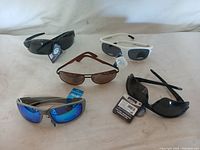 Five pairs of Mil-Tac ballistic safety glasses in various colors arranged on a white surface.