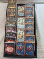 Top view of multiple CCG cards arranged in rows, featuring Clash of Devs backs and various front designs.