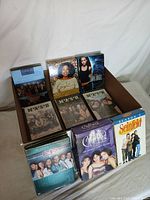 Photo showing assorted TV show DVD sets including multiple M*A*S*H sets, Oprah 20th Anniversary, Charmed, ER, and Seinfeld Season 3.