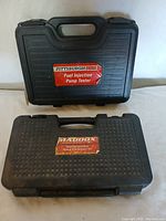Black hard plastic carrying case labeled 'Pittsburgh Fuel Injection Pump Tester' with handle on top, closed.