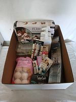 Photo of the entire lot in a cardboard box showing various pamper and enhancement products arranged inside.