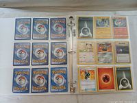 Open binder showing front sides of multiple Pokémon cards such as Hitmonlee, Meowth, Trainer card, Fire energy.