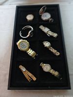 Tray with eight vintage watches in used condition, variety of styles and band types.