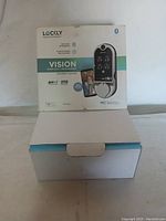 Front view of the Lockly Vision Smart Lock and Video Doorbell box showing product image and key features including HD camera, Bluetooth, and advanced security features.