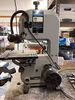 Full view of Delta Shopmaster BS100 benchtop bandsaw on workbench