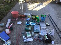 Overview of assorted garden supplies spread on pavement