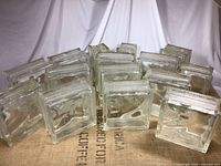 Group of clear glass blocks arranged on a fabric surface showing size and texture.