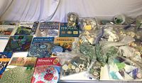 Photo showing 10 mosaic books and multiple bags filled with colorful mosaic glass and ceramic pieces.