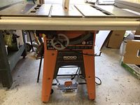 Front view of orange Ridgid table saw on folding stand