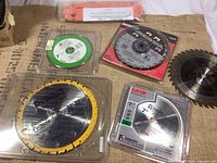 Overview of all saw blades including the Leecraft zero clearance table saw insert showing packaged and unpackaged blades.