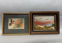 Two framed artworks side by side: oil painting with birds in landscape on right, woven silk hummingbird artwork on left