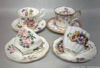 Four vintage floral teacups and saucers arranged together showing variety of patterns and gold edged rims.