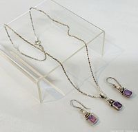 Full set showing the necklace and earrings together on display stand.