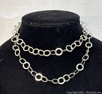 Photo showing the necklace doubled around a black display bust, highlighting the design of alternating circular and oval links.