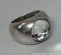 View of silver ring with cabochon crystal showing polished and worn surfaces.