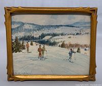 Front view of entire framed watercolor showing ski scene and carved gold frame