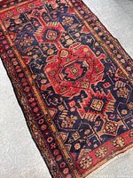 Angle close-up showing central medallion and intricate floral pattern on navy blue background