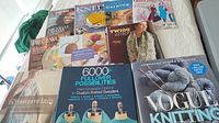 Top view of knitting and textile art books arranged on bed showing titles and covers