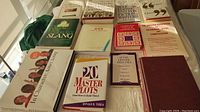 Lot of 11 assorted books on language, writing, acting, plotting, and communication shown on a table.