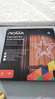 Photo of the front of the box showing NOMA brand Rope Light Star product with star design and color options
