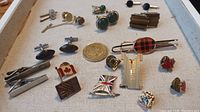 Image showing a collection of men's lapel pins, cufflinks, and tie clips arranged on a tray