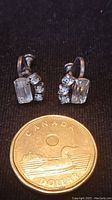Front view of vintage Jay-Flex sterling silver rhinestone earrings with Canadian dollar coin for size reference
