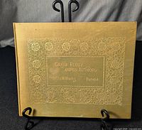 Front cover of the antique hardcover book showing the gold embossed title and decorative border.