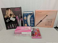 Overview of all items in the lot showing 3 curling wand products, pore cleaner, nail drill and nail tool kit