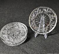 Four Godinger Dublin crystal coasters stacked with one displayed upright on a stand, showing the diamond and starburst cut pattern