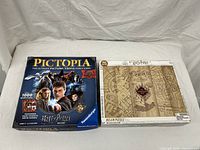 Photo of both items showing the Pictopia Harry Potter trivia game box and unopened Harry Potter puzzle box featuring Marauder's Map design.